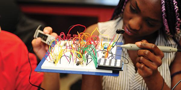 girl working on electronics board